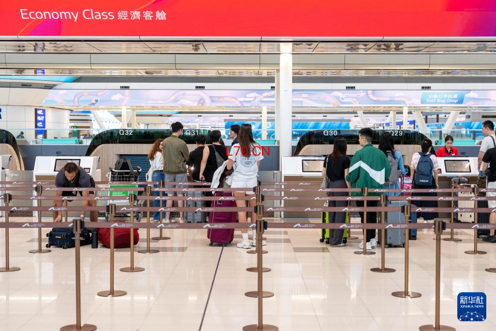5月27日,旅客在香港国际机场二号客运大楼离境大堂办理手续。新华社记者 朱炜 摄