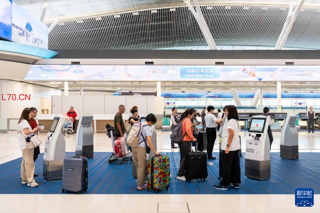 5月27日,旅客在香港国际机场二号客运大楼离境大堂办理手续。新华社记者 朱炜 摄