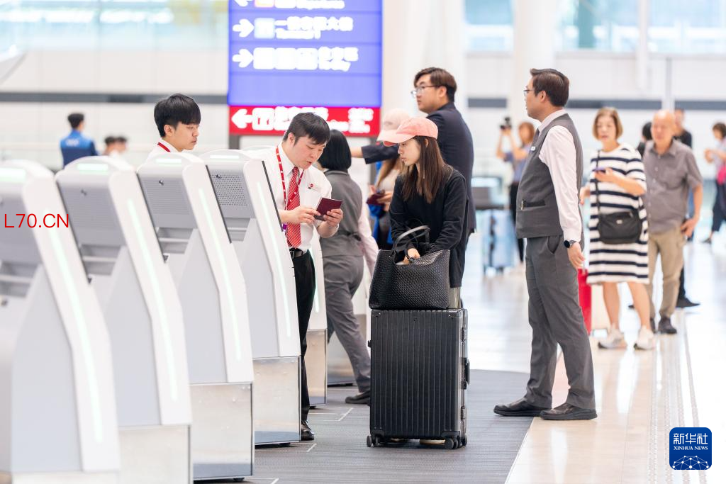 5月27日,旅客在香港国际机场二号客运大楼离境大堂办理手续。新华社记者 朱炜 摄